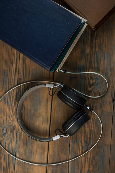 Audiobooks kitap ve kulaklıkları ahşap masada siyah. Üst görünüm - Fotoğraf, Görsel