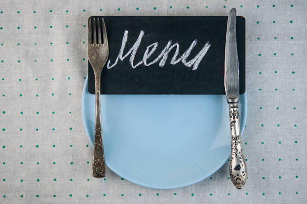 Σχεδιασμός μενού εστιατορίων. Εστιατόριο μενού με άδειο πιάτο και μαχαιροπήρουνα, σε φόντο polka dot με πολύχρωμη πετσέτα. Κάτοψη με χώρο αντιγραφής για κείμενο - Φωτογραφία, εικόνα