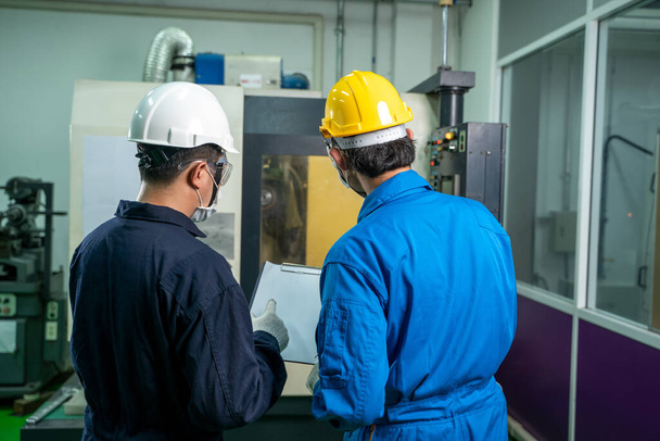 Mitarbeiter einer Industriefabrik bei der Arbeit und Kontrolle in der Nähe von Stromzählern eines Kontrollraums in einer Industriefabrik. - Foto, Bild