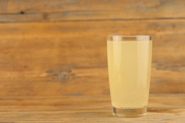 Lemonade on a glass cup on wood table - Foto, afbeelding
