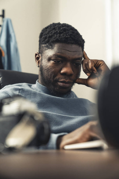 Thinking black man working on laptop computer - portrait shot - Zdjęcie, obraz