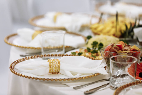 une table avec une nappe, une belle portion de plats blancs, une belle assiette, dîner dans un restaurant
. - Photo, image