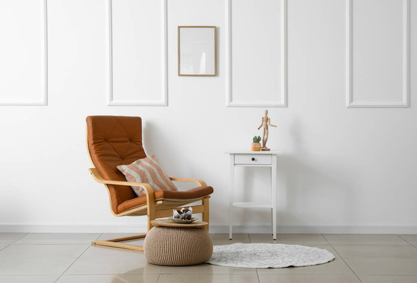 Interiér světlého obývacího pokoje s křeslem, stolem a béžovým pouzdrem - Fotografie, Obrázek