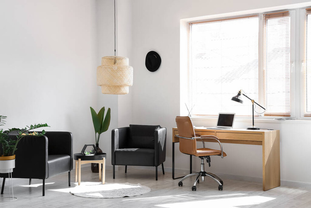 Interior of modern office with workplace and black armchairs - Foto, imagen