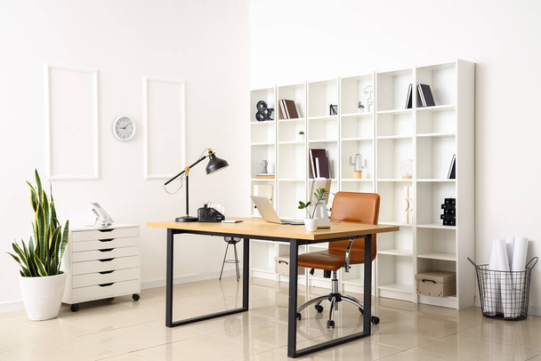 Lugar de trabajo moderno con portátil y lámpara en el interior de la oficina de luz - Foto, Imagen