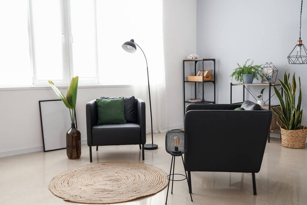 Интерьер стильной гостиной с современными креслами и светильниками - Фото, изображение