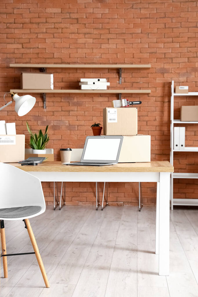 Kartondoboz tárgyakkal és bútorokkal az iroda belsejében a költözés napján - Fotó, kép