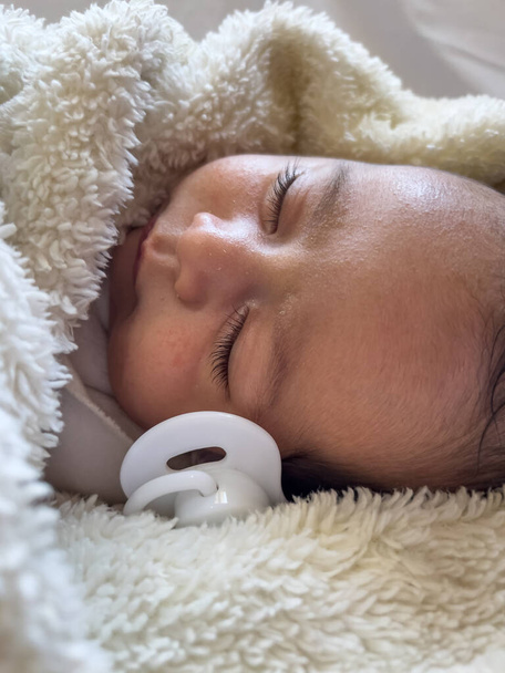 Γλυκό γαλήνιο μωρό ξαπλωμένο σε λευκό σεντόνι, απολαμβάνεις τον πρωινό ύπνο. - Φωτογραφία, εικόνα