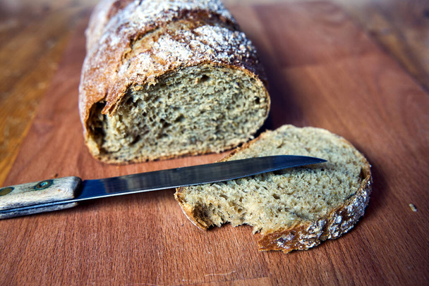 Bochník chleba a nůž na dřevěném stole v Polsku - Fotografie, Obrázek
