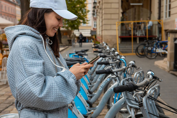 nő bérlése városi kerékpár mobil app modern ökológiai közlekedés - Fotó, kép