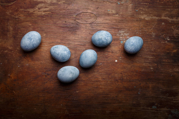 Huevos azules pintados de Pascua sobre fondo rústico de madera marrón. Copiar espacio, vista superior - Foto, imagen