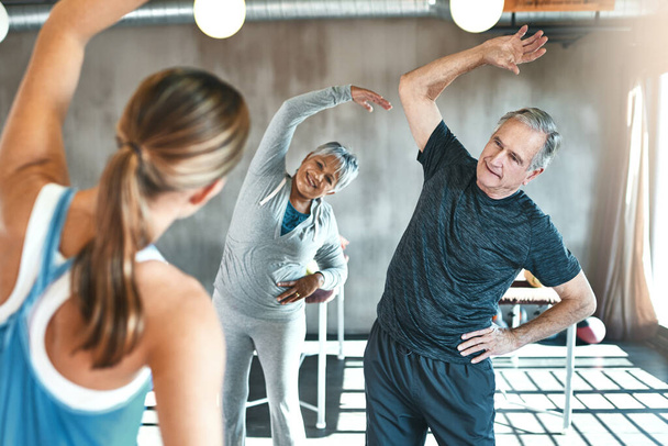 Healthy hearts are happy hearts. Shot of a senior man and woman working out with the help of an instructor. - Foto, afbeelding
