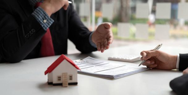 Agent nieruchomości zaproponował warunki do klientów, którzy podpisują umowy kupna domu z ubezpieczeniem, Umowa do podpisania koncepcji umowy kupna - Zdjęcie, obraz