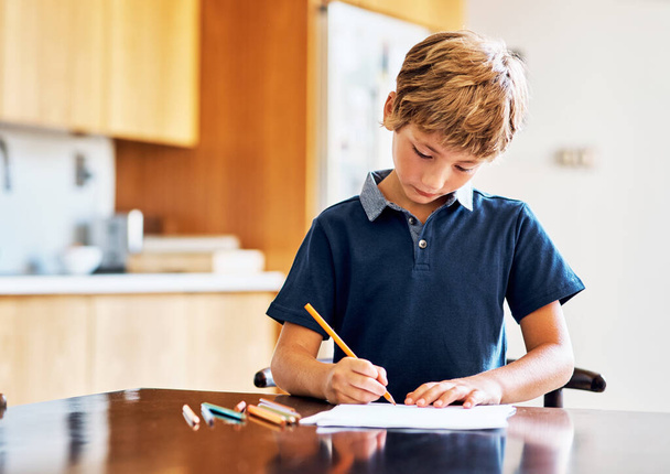 Time for homework, then time for play. Shot of a young boy doing his homework. - Photo, Image
