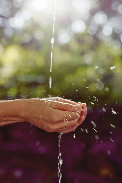 水と命は一つです。屋外で手を洗っている女性の作物のショット. - 写真・画像