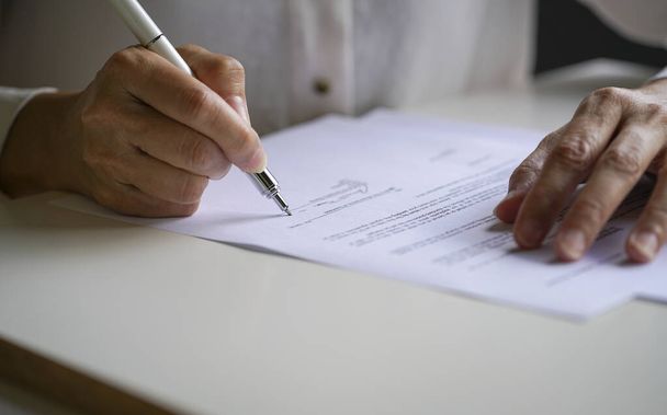 Businesswoman putting her signature on a contract agreement. Close up view with copy space. - 写真・画像