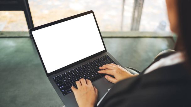 オフィスの空白の白いデスクトップ画面とラップトップコンピュータを使用して入力するビジネスマンのモックアップイメージのトップ表示 - 写真・画像