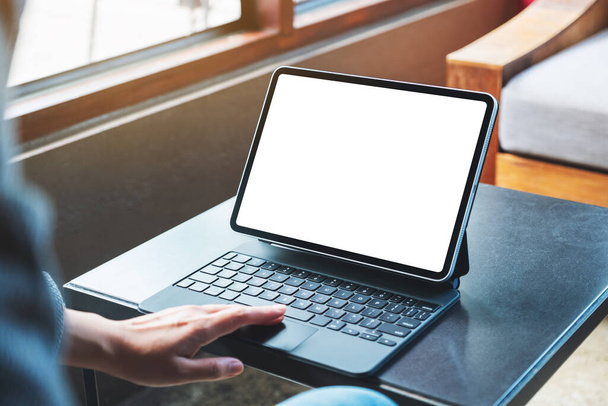 Imagem Mockup de uma mão usando e tocando tablet touchpad com tela de desktop branca em branco como PC do computador  - Foto, Imagem