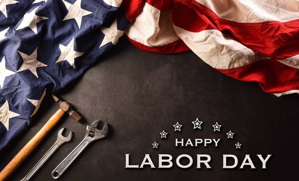 Happy Labor day concept. American flag with different construction tools and the text on dark stone background. - Photo, Image
