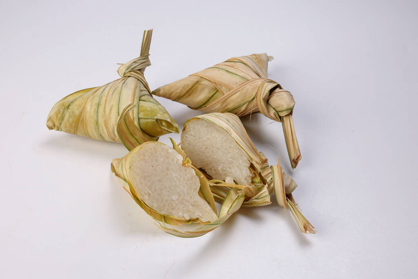 Tradicional bolso de hoja de palma tejida en forma de diamante al vapor glutenoso pastel de arroz ketupat kupat tipat sobre fondo blanco - Foto, imagen