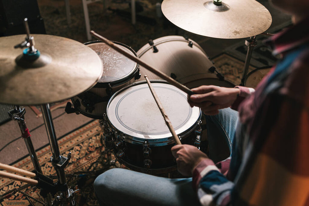 Человек, практикующий барабаны в студии во время репетиции - Фото, изображение