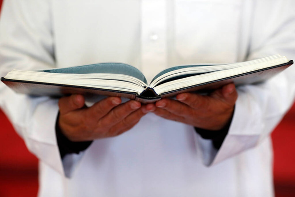 Μουσουλμάνος διαβάζει το ιερό Κοράνι στο τζαμί.  - Φωτογραφία, εικόνα