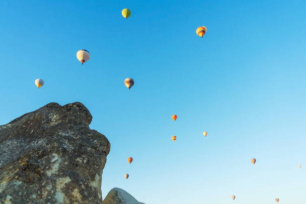 Luftballons vor einem blauen Himmel ohne Wolken. Luftballons am Himmel in Kappadokien in der Türkei. Viele kleine Luftbälle fliegen in den Himmel - Foto, Bild
