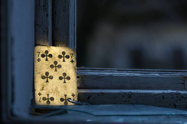 φωτεινή κάρτα που στέκεται στο περβάζι του παραθύρου από ένα εγκαταλελειμμένο σπίτι - Φωτογραφία, εικόνα