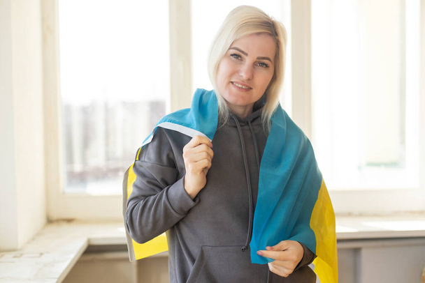 kobieta zawinięta w flagę Ukrainy. - Zdjęcie, obraz