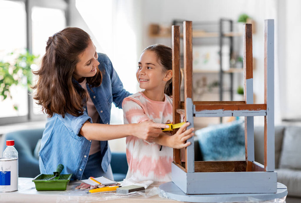 mother and daughter with ruler measuring old table - Foto, Imagem