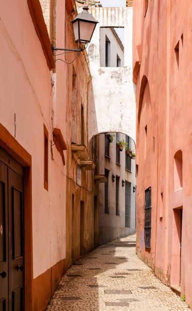 Badajoz, Španělsko - 27. března 2022: úzká pěší ulička vedoucí vysokými kolorovanými domy - Fotografie, Obrázek