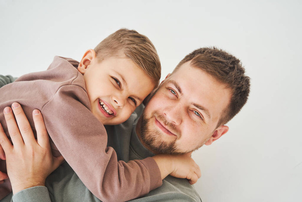 Close-up portret van lachende vader en zoon. Knappe vader en vrolijk en emotioneel kind. Vaderschap - Foto, afbeelding