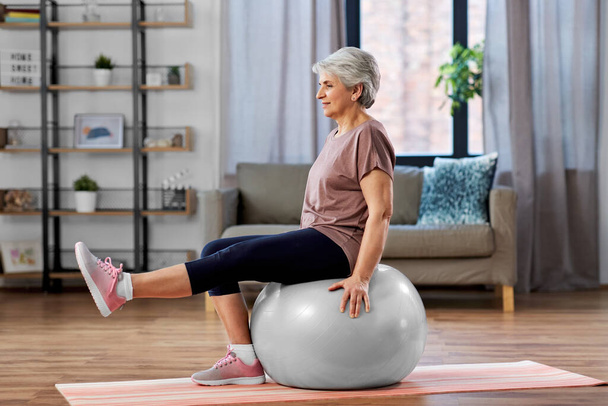 senior woman training with exercise ball at home - Fotografie, Obrázek