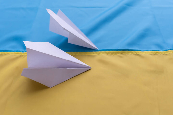 aereo di carta sullo sfondo bandiera dell'Ucraina, bandiere del paese, blu, giallo - Foto, immagini