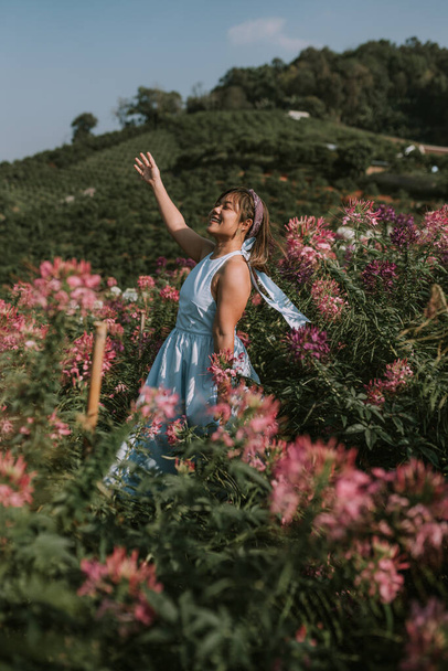 Thai woman is walking in flower field - Photo, Image