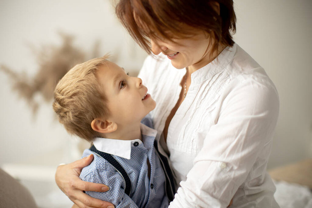 Mother and child, blond fashion preschool boy, having a wonderful family happy moment together, enjoying the relation - Photo, image