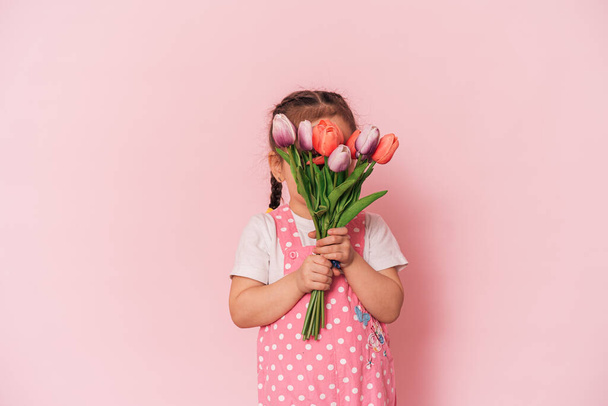 Little girl with bouquet of tulips against pink background happy mothers day, - Zdjęcie, obraz