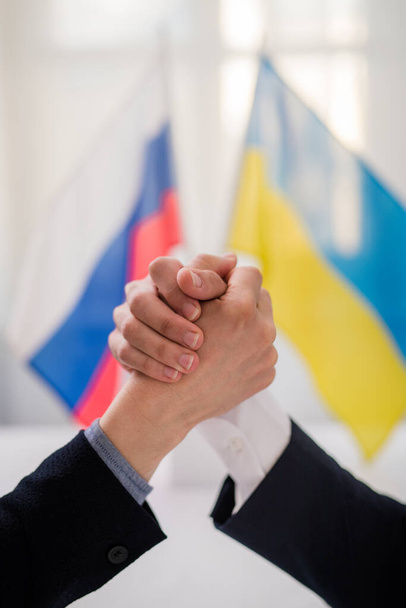 Representatives of Ukraine and Russia shaking hands, Ukraine peace agreement concept. - Fotografie, Obrázek