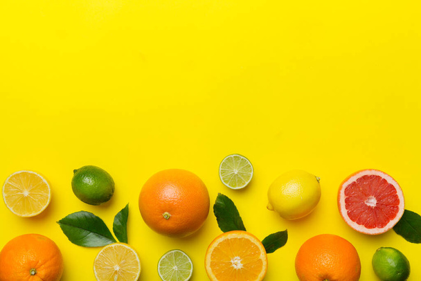 Fruit achtergrond. Kleurrijke verse vruchten op gekleurde tafel. Oranje, citroen, grapefruit Ruimte voor tekst gezond concept. Vlakke lay, bovenaanzicht, kopieerruimte. - Foto, afbeelding