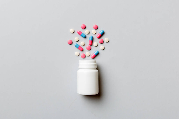 Pillole e capsule multicolori in flacone di plastica su sfondo colorato, copiare spazio. Molti diversi vari farmaci compresse e pillole, vitamine e integratori alimentari concetto. - Foto, immagini