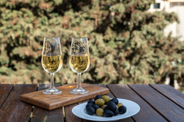Γευστική δοκιμή ισπανικού γλυκού και ξηρού οχυρωμένου οίνου Vino de Jerez sherry και ελιάς σε στέγες και σπίτια της παλιάς ανδαλουσιανής πόλης, νότια της Ισπανίας - Φωτογραφία, εικόνα
