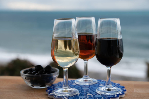 Ochutnávka španělského sladkého a suchého opevněného vína Vino de Jerez sherry a zelených oliv s výhledem na modré moře a pláž v blízkosti El Puerto de Santa Maria, Andalusie, Španělsko - Fotografie, Obrázek