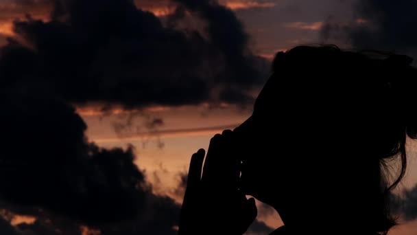 silueta de mujer meditando al atardecer nublado magnífico, silueta de mujer rezando - Metraje, vídeo