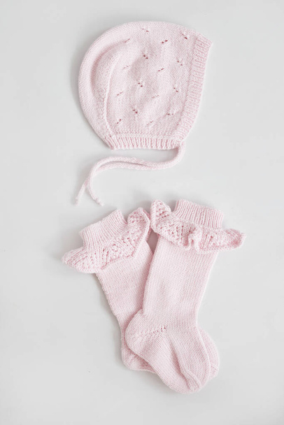 Knitted socks and bonnets. Knitted kids clothes and accessories for knitting. Needlework and knitting. Hobbies and creativity. Knit for children. Handmade. Hobbies and creativity. - Photo, Image