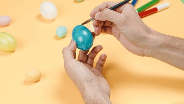 pintura a mano coloridos huevos de Pascua sobre fondo amarillo  - Foto, Imagen