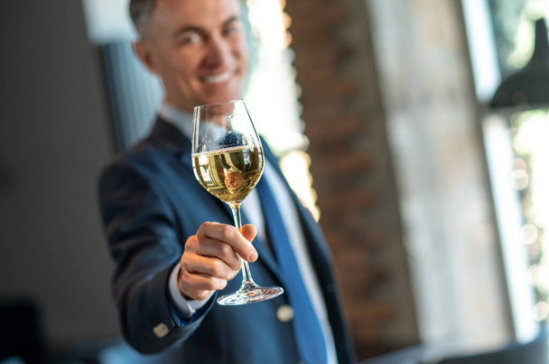 Smiling man with a glass of wine in hands - Foto, afbeelding