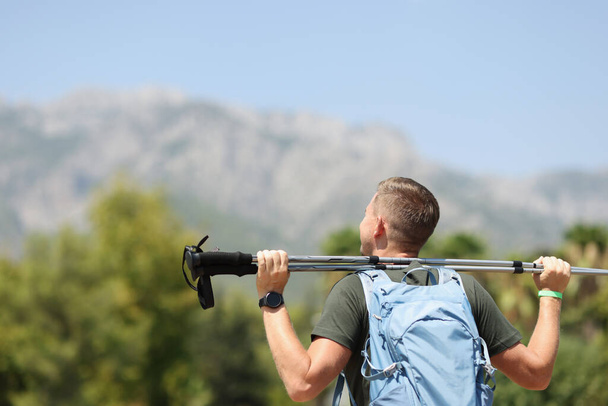 Man holds trekking stick on mountain closeup - 写真・画像