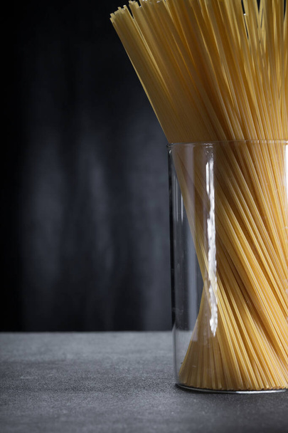 minimalistisch beeld van spaghetti pasta in een glazen pot close-up. - Foto, afbeelding