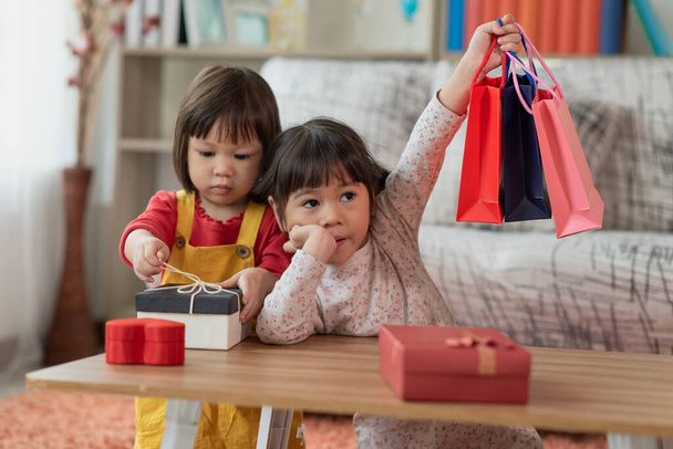Feliz niño asiático con los brazos arriba sosteniendo bolsas de compras, caja de regalo concepto de Navidad y Año Nuevo niño - Foto, imagen