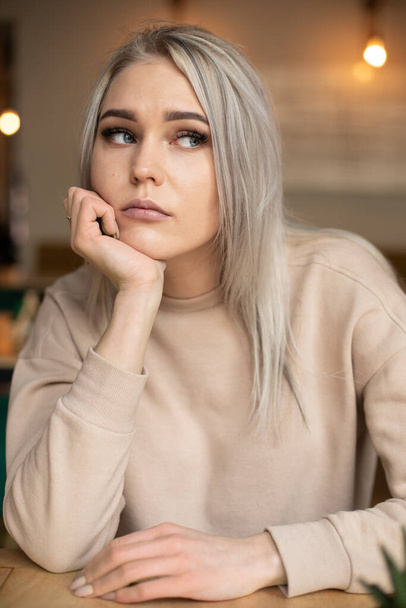 Portrait of young attractive thoughtful woman with long grey hair with cute professional make-up resting chin on hand. - Photo, Image